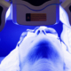Blue light therapy session preparing a patient’s skin before plastic surgery.