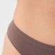 Close-up of a smooth, flat stomach after a tummy tuck surgery, showing natural belly button placement and minimal visible scarring above neutral underwear.